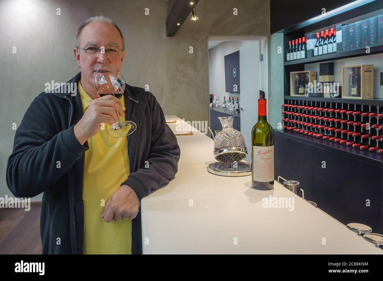A male tourist enjoys a wine tasting session with the iconic Penfolds Grange at the Penfolds Cellar Door in the Barossa Valley in South Australia. Stock Photo
