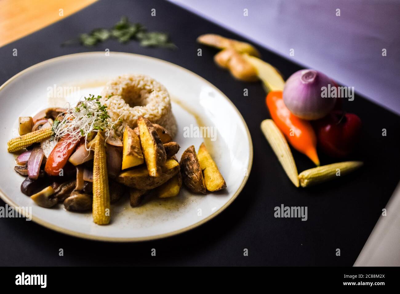 Tasty dish with roasted potatoes, mushrooms baby corns and rice Stock Photo