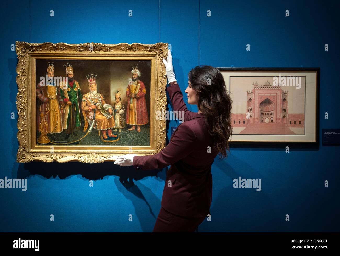 Curator Emily Hannam takes a closer look at a mid-nineteenth century oil painting by a Mughal artist depicting Emperor Akbar Shah II with his sons and grandsons at a press preview for the Royal Collection's Eastern Encounters exhibition in The Queen's Gallery at the Palace of Holyroodhouse, Edinburgh. Stock Photo