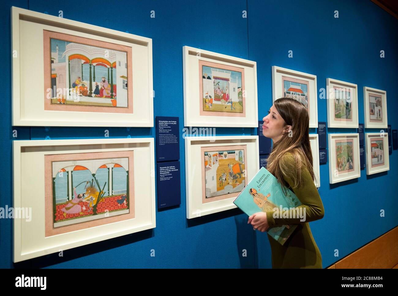 Senior exhibition coordinator Hannah Belcher takes a closer look at Scenes from the Bhagavata Purana created by the Nainsukh family workshop in the late eighteenth century at a press preview for the Royal Collection's Eastern Encounters exhibition in The Queen's Gallery at the Palace of Holyroodhouse, Edinburgh. Stock Photo