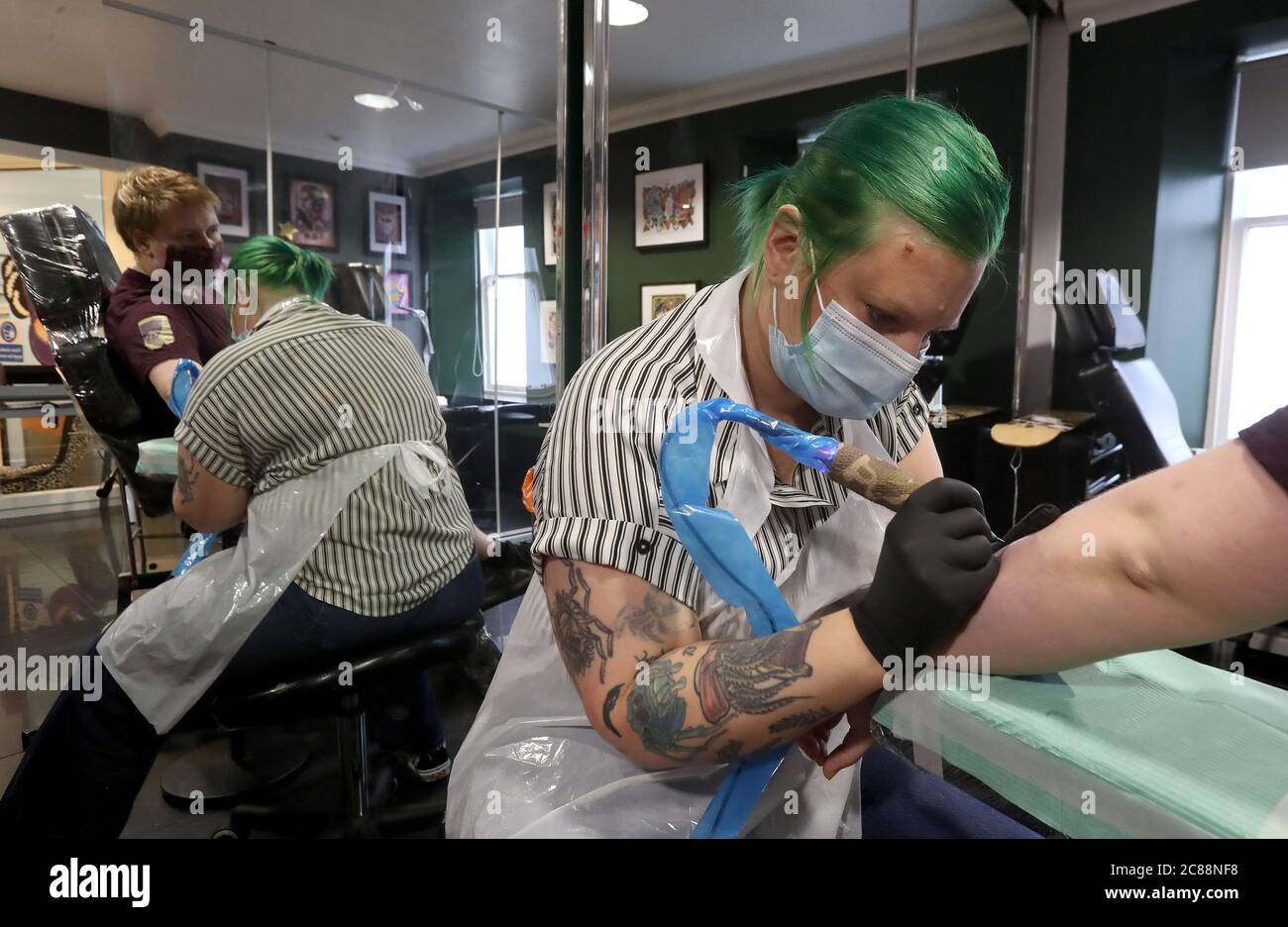 Tattoo Artist Tam Hadfield From Heaven N Hell Tattoo Studios In Falkirk With Client Drew Jamieson As Scotland Continues With The Gradual Lifting Of Restrictions To Ease Out Of Lockdown Stock Photo