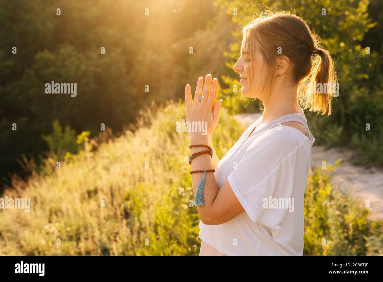 Middle shot portrait of hands and faces of meditating woman doing