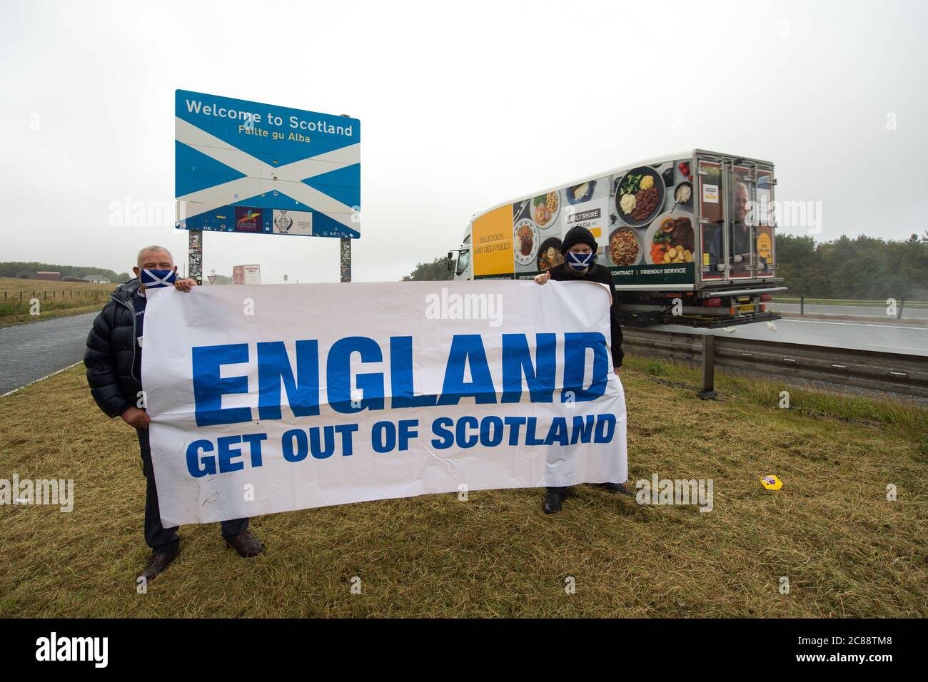 Scottish/English Border at Berwick, Scotland, UK. 22 July 2020 Pictured: (L-R) James Connelly; Sean Clerkin of Action For Scotland.  All people must stop travelling from England to Scotland for non essential reasons to protect the people of Scotland from Covid-19. New cases of Covid-19 Are 5.5 Times higher In England than Scotland and Professor Rowland Kao a mathematical biologist at EDINBURGH University stated recently that if there is increased travel between England and Scotland it is inevitable that cases of Covid-19 will increase in Scotland. Credit: Colin Fisher/Alamy Live News. Stock Photo