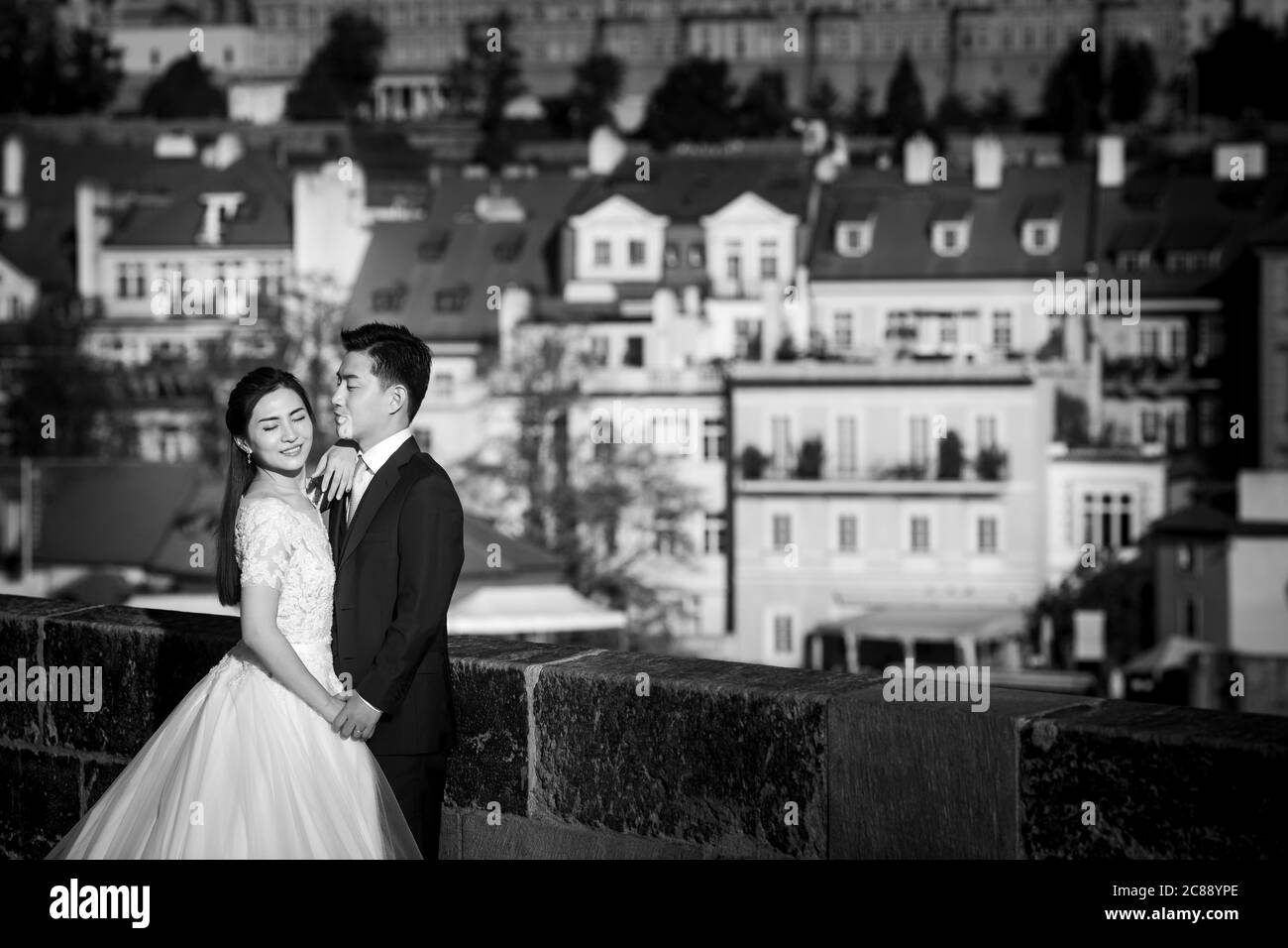 Prague, Czech Republic. 5th October, 2018. A wedding couple poses for the picture in front of the St. Nicholas Church from Charles Bridge in Prague. Stock Photo