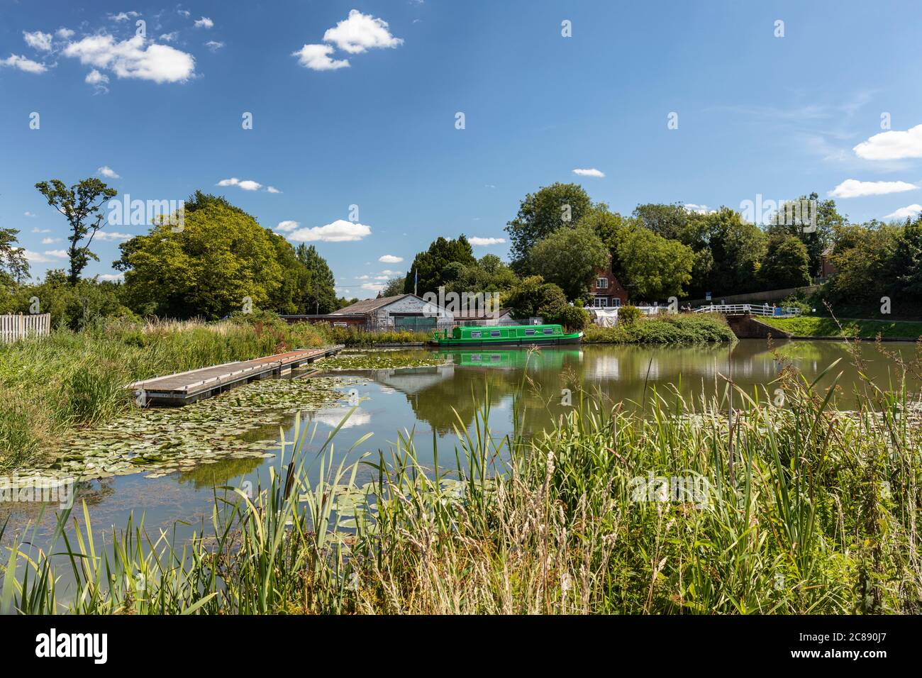 A green canal boat in the side pond at Lock 44 and Caen Hill Cafe, Caen Hill Locks, Kennet and Avon Canal, Devizes, Wiltshire, England, UK Stock Photo