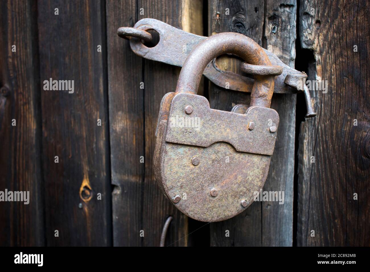 Large rusty lock on the wooden barn door Stock Photo - Alamy