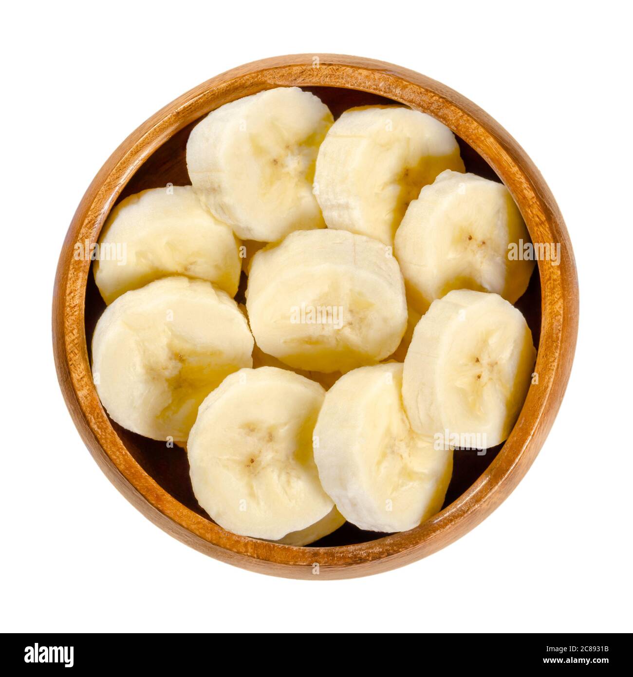 Fresh banana slices in wooden bowl. Ripe and peeled banana cut into round pieces. Edible and ready to eat dessert fruit with slightly yellow color. Stock Photo