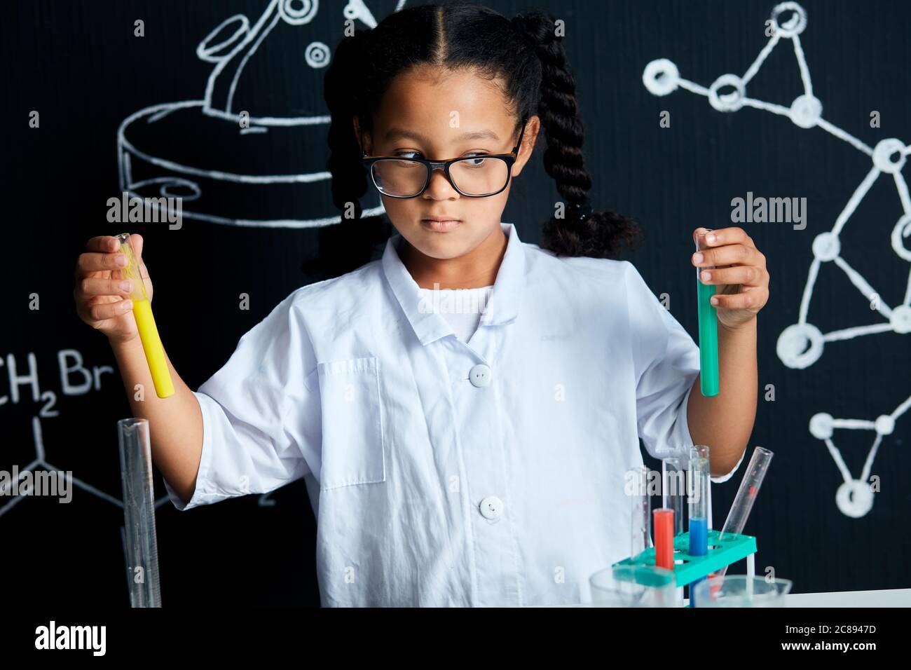 Mixed race asian little girl wearing white lab coat and protective