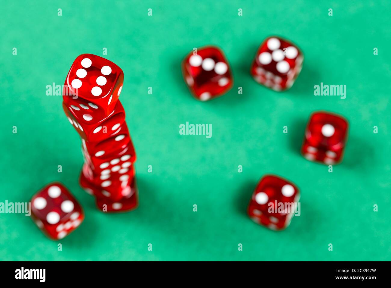 stack of red dice on green felt texture Stock Photo