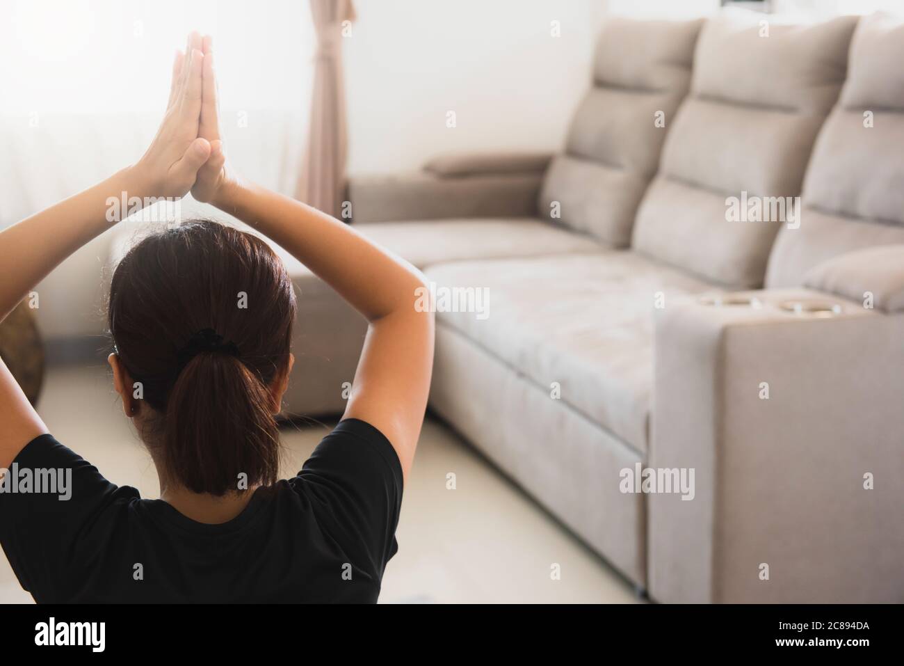 Yoga at home, woman do lotus pose, Padmasana asana. Young girl exercise. Stock Photo