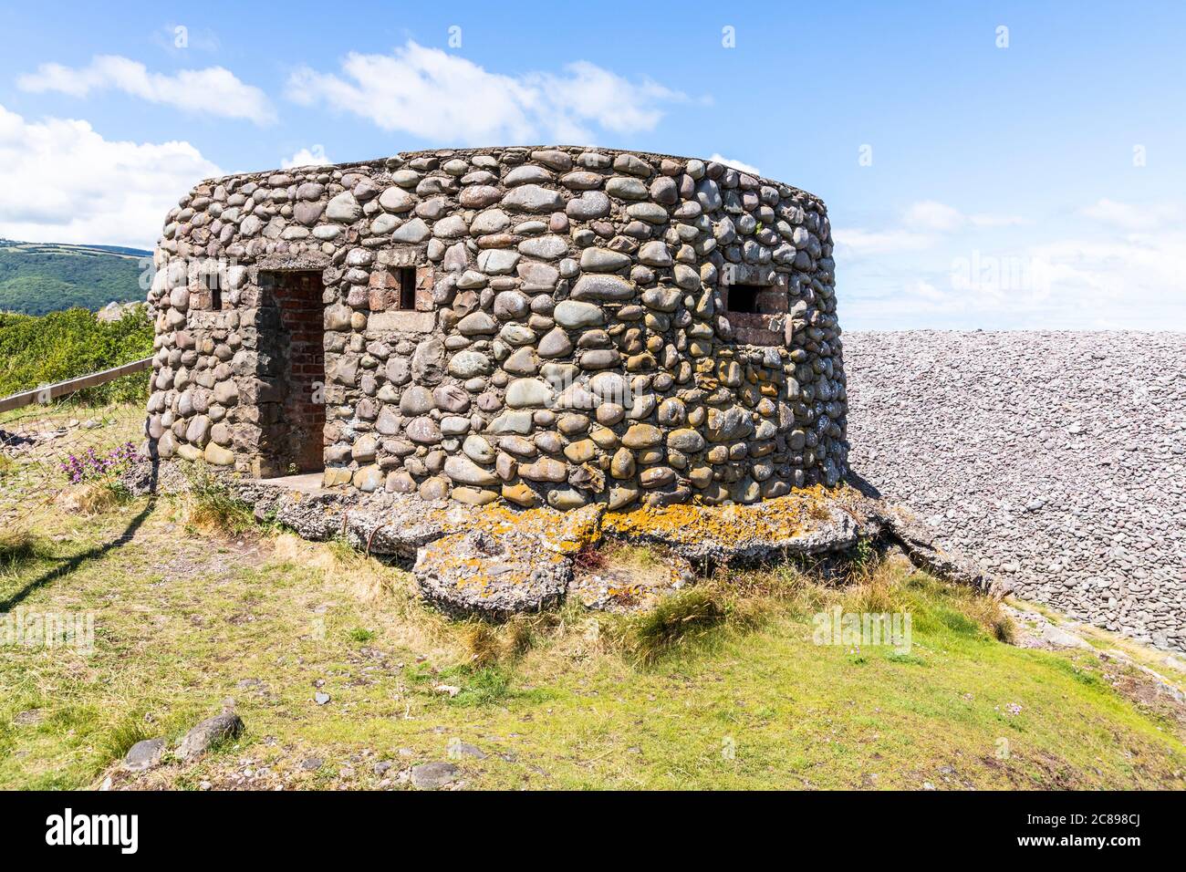 A pebble built pill box on the shingle and pebble barrier ridge of Bossington Beach on the coast of  Exmoor National Park, Somerset UK Stock Photo