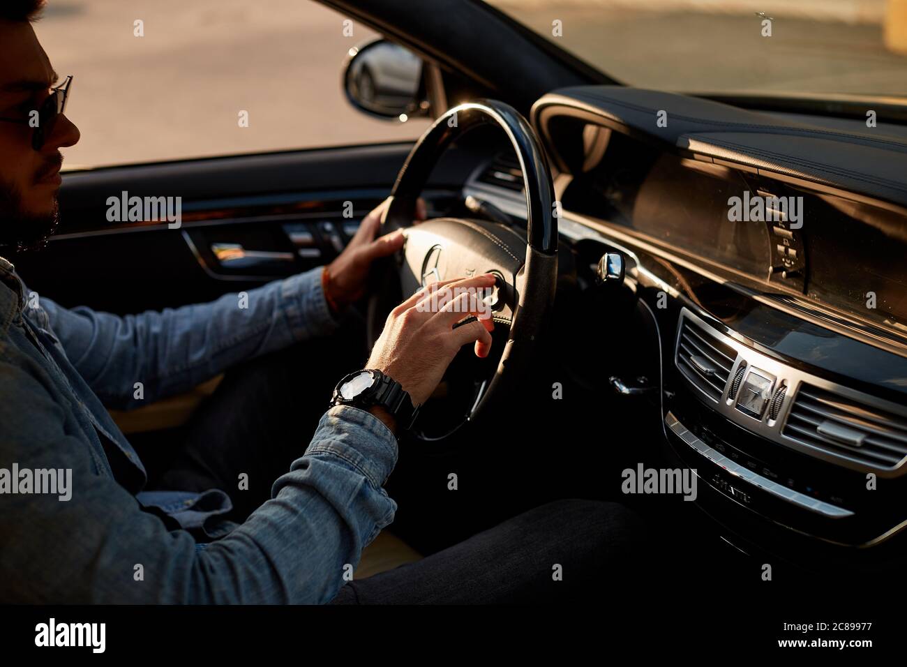 handsome man in casual clothes dvring a car and beeping. close up side view photo Stock Photo