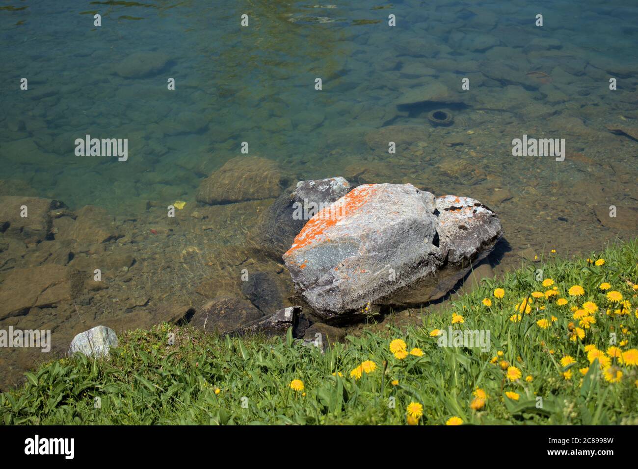 Big rock is lying at the bay of the lake Saint Moritz Stock Photo