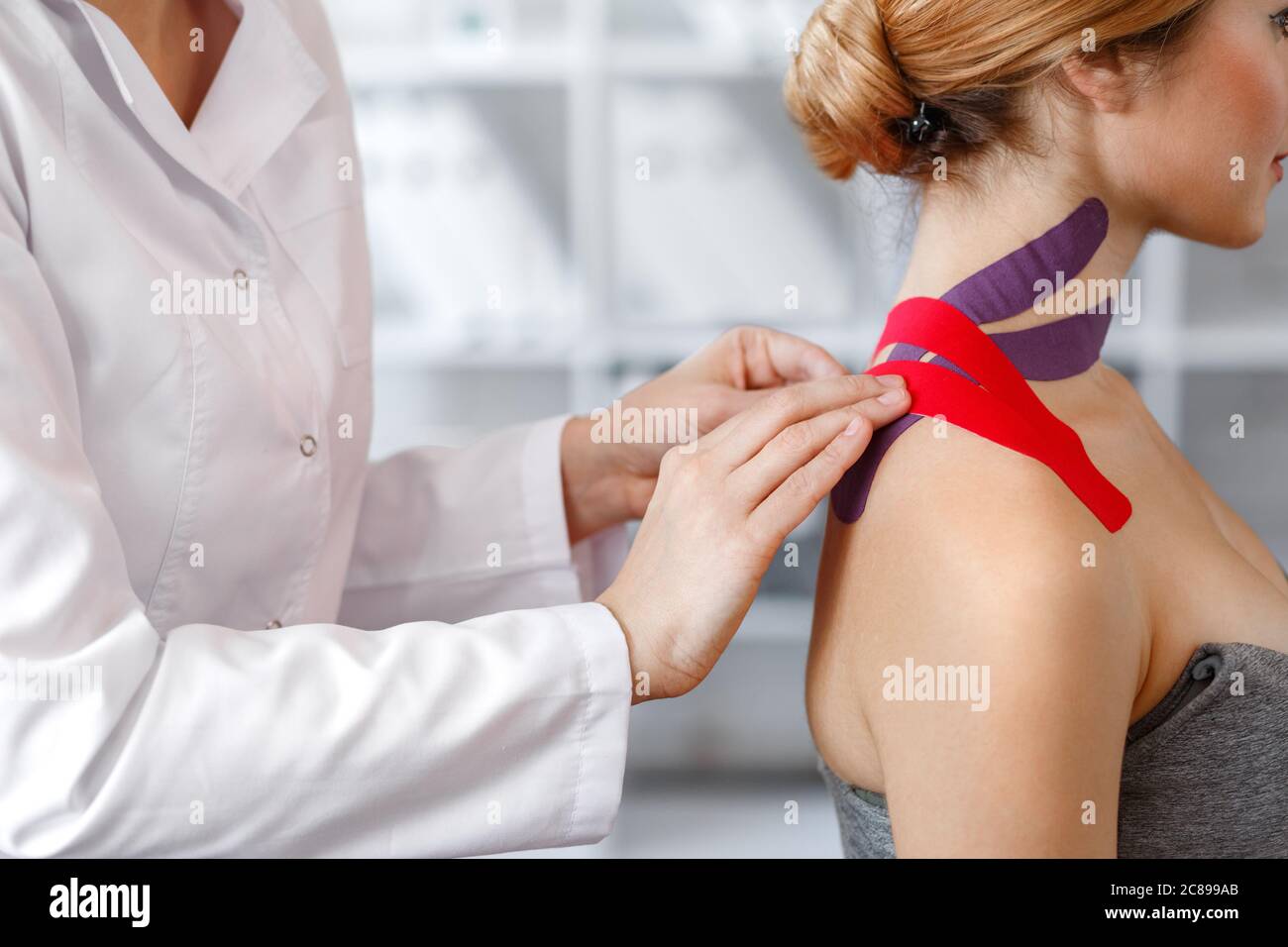 Kinesiology taping. Physical therapist applying kinesiology tape to