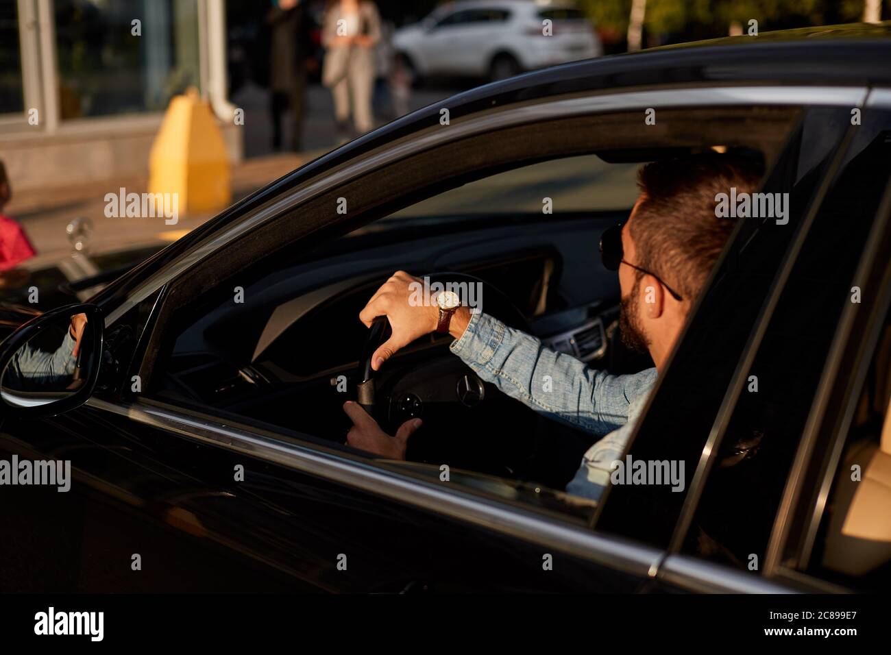 handsome car Driver Holding a Steering Wheel While travelling. nback vieww photo. close up back view photo. Stock Photo