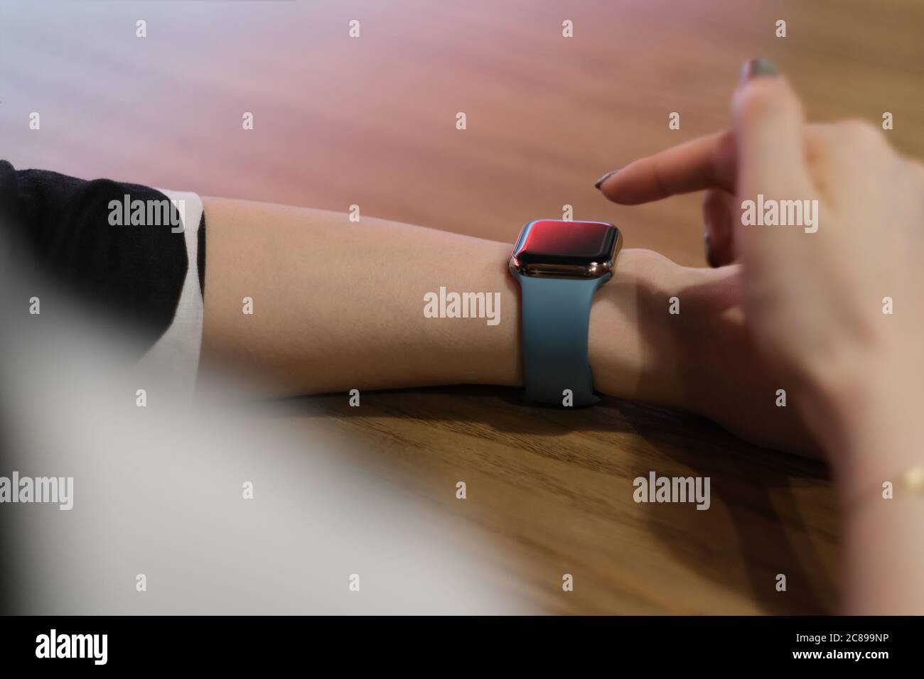 over shoulder view of woman using smart watch. blur background Stock Photo