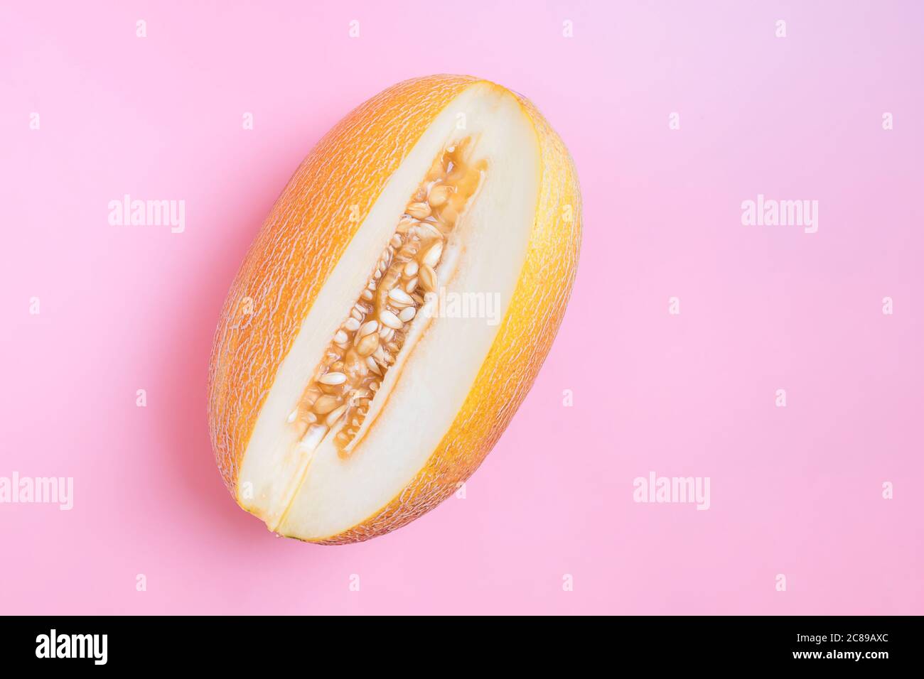 Melon half on orange background. Creative layout made of fresh melon. Flat lay, top view, copy space Stock Photo