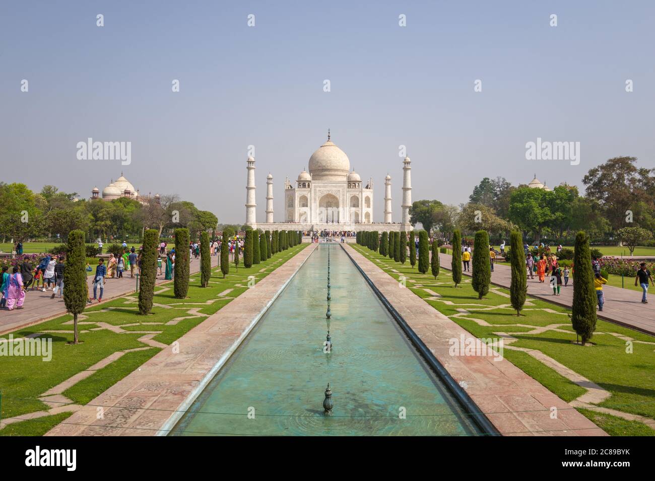 Taj Mahal on sunny April day, with walkways and water leading to the building - features visitors Stock Photo