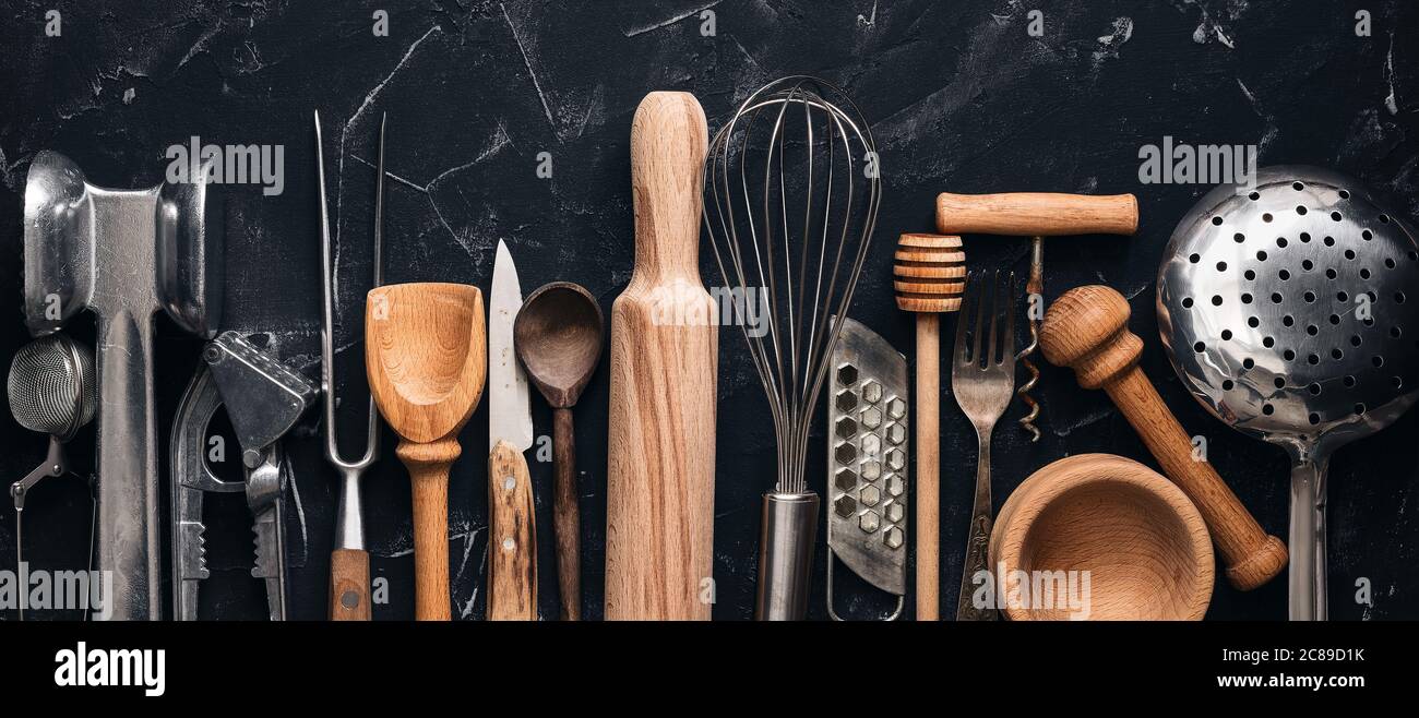 Various kitchen utensils and tools on a black stone background, banner. Top view, flat lay. Collection kitchenware Stock Photo