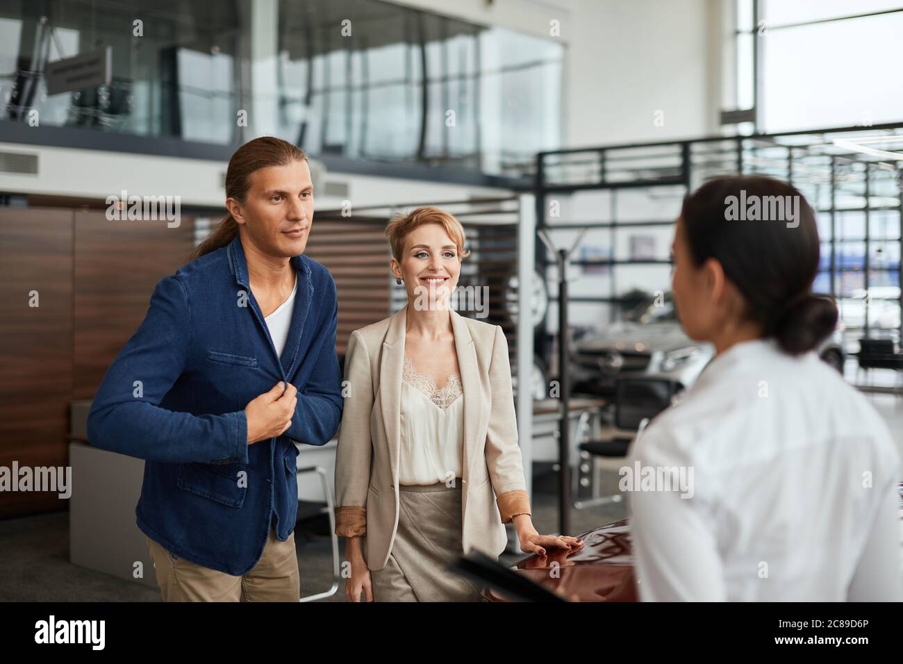 Professional ambitious sales agent prompting the young couple to buy a