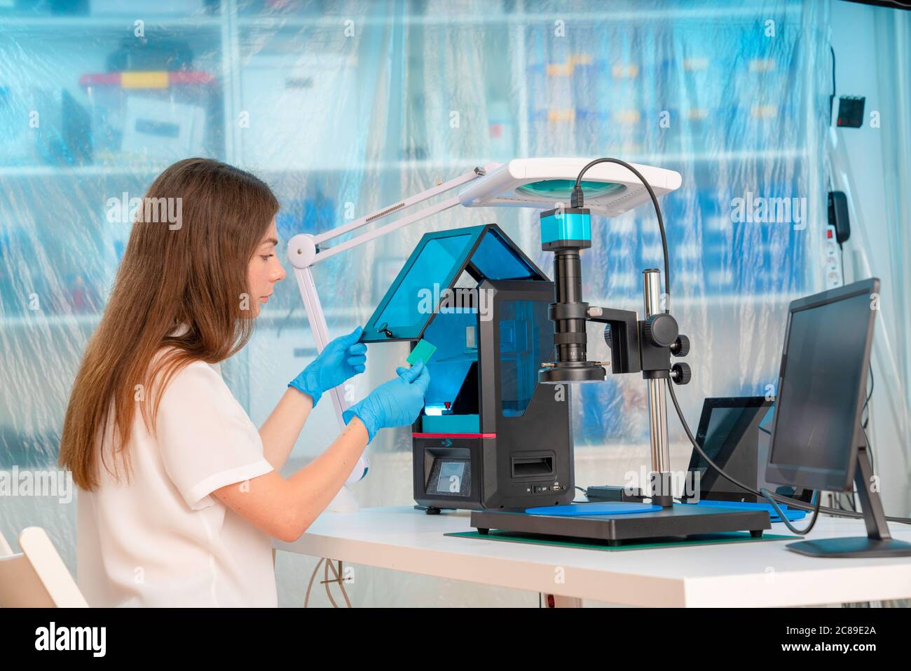 Woman worker in control of Resin LCD / DLP / SLA 3D Printer in technology lab Stock Photo