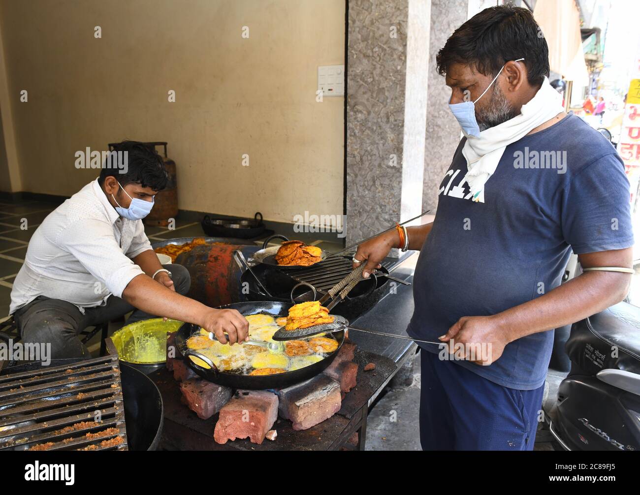 Beawar, Rajasthan, India, July 22, 2020: Confectioner makes 'Malpua' on the occasion of 'Sinjara' ahead of Hariyali Teej festival in Beawar. Teej celebrated by women in many states of India and by Hindus women of Nepal. Hariyali Teej or Hartalika Teej welcome the monsoon season. The festival dedicated to Goddess Parvati & her union with Lord Shiva. In this festival woman follow a ritual of not eating anything for long life of her husband. The day before Teej is celebrated as Sinjara, wherein women put mehandi on their hands & eat Ghevar-Malpua sweet. Credit: Sumit Saraswat/Alamy Live News Stock Photo