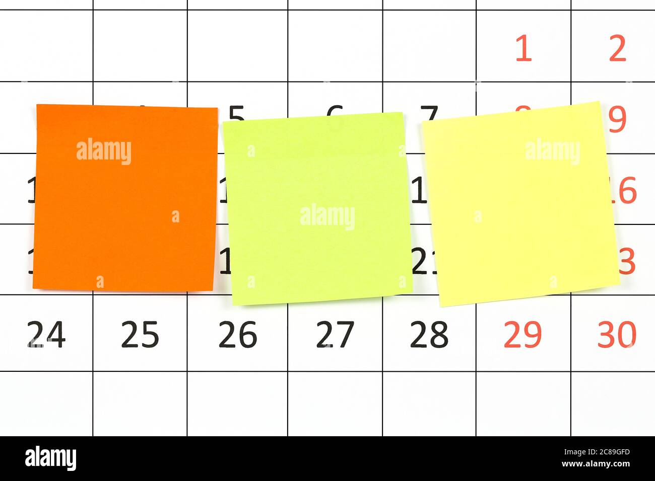 three colorful adhesive notes on calendar Stock Photo - Alamy