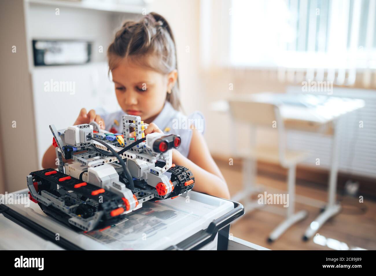 Schoolgirl holding constructor robot in robotics class Stock Photo