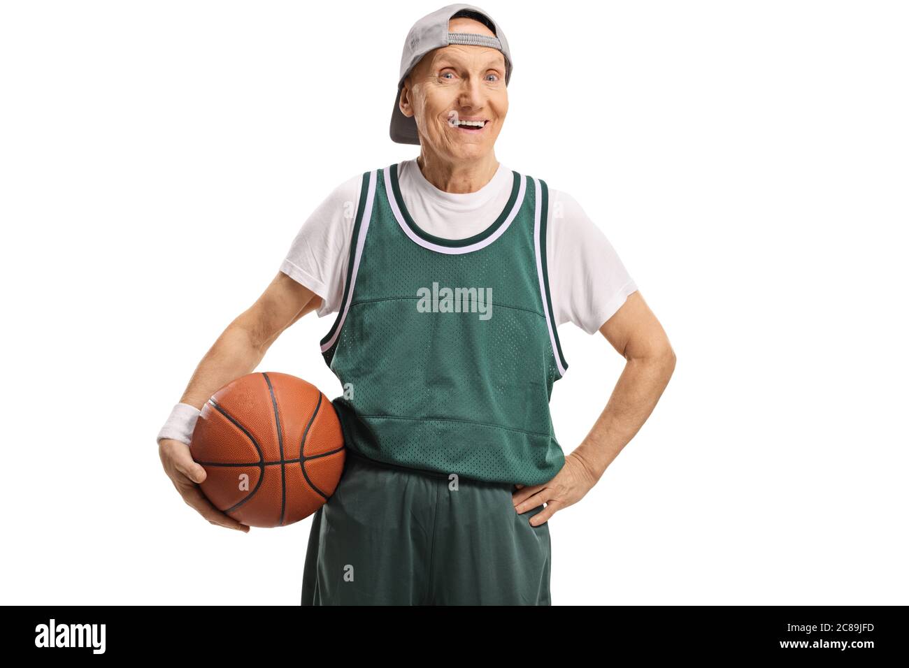 Elderly man in a green jersey holding a basketball isolated on white background Stock Photo