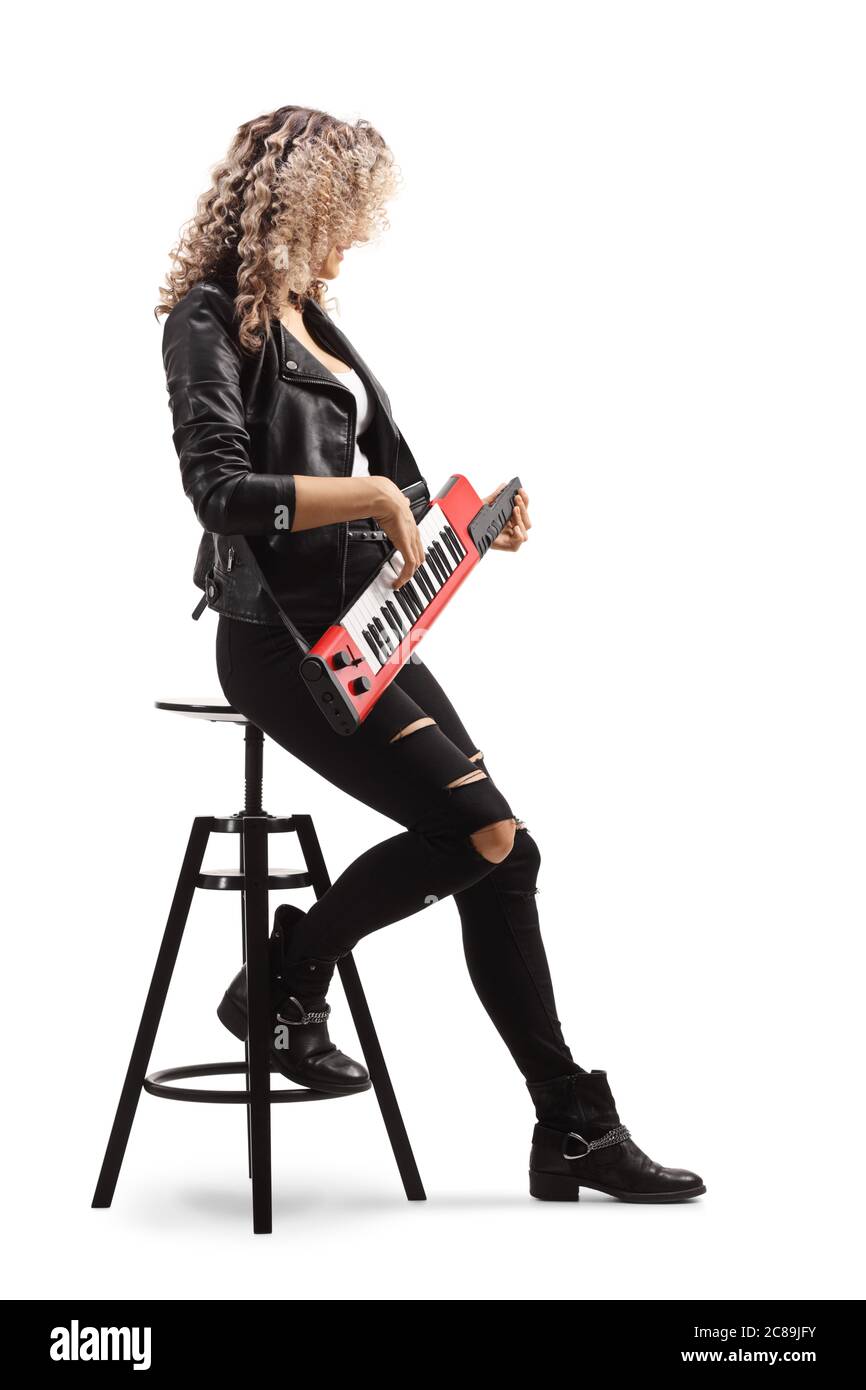 Woman sitting on a chair and playing a keytar synthesizer isolated on white background Stock Photo