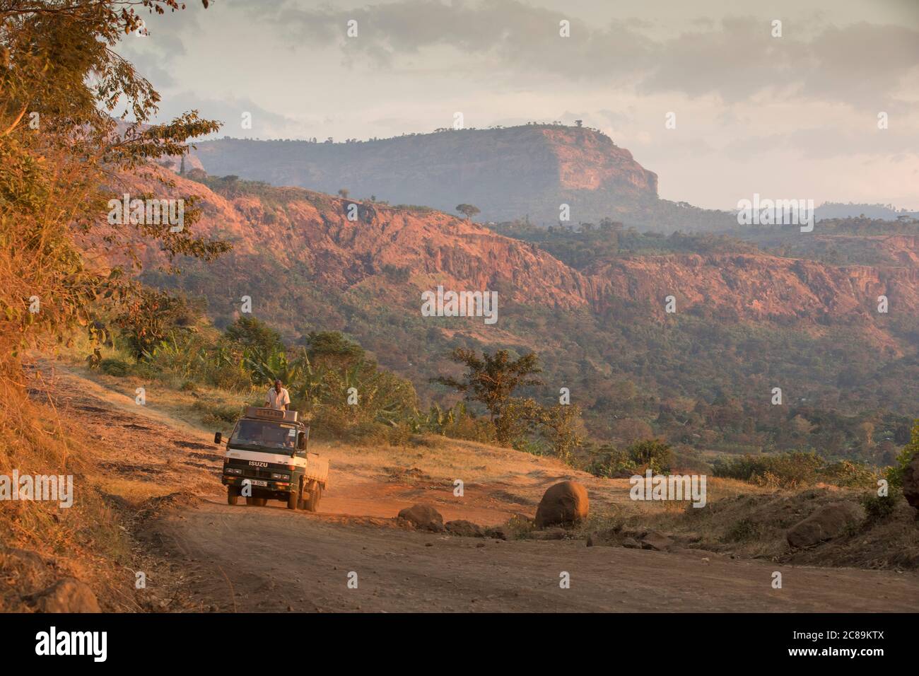 Trucks navigate steep Mt.Elgon mountain roads while passing through beautiful scenery in Bulambuli Dist., Uganda, Africa. Stock Photo