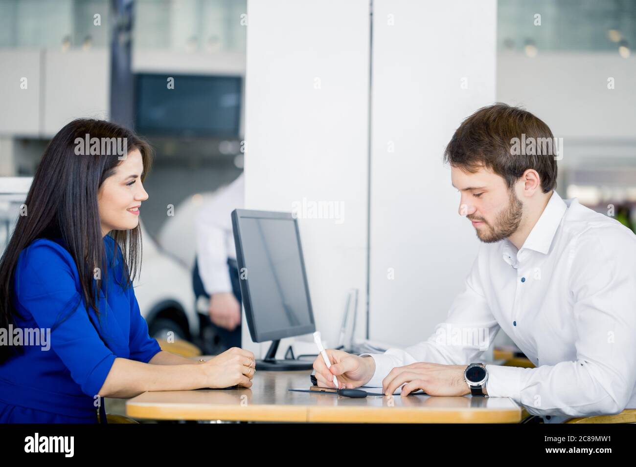 Young caucasian couple of just married people taking decision of buying a car in the dealer office Stock Photo