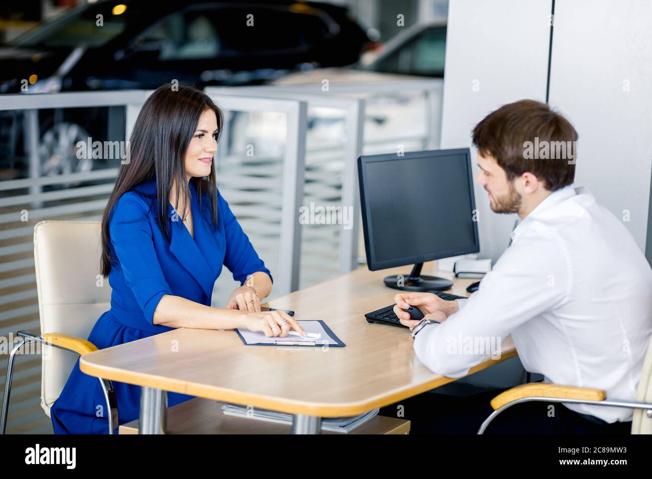 Customer woman asking dealer about definite terms in loan agreement in meeting room Stock Photo