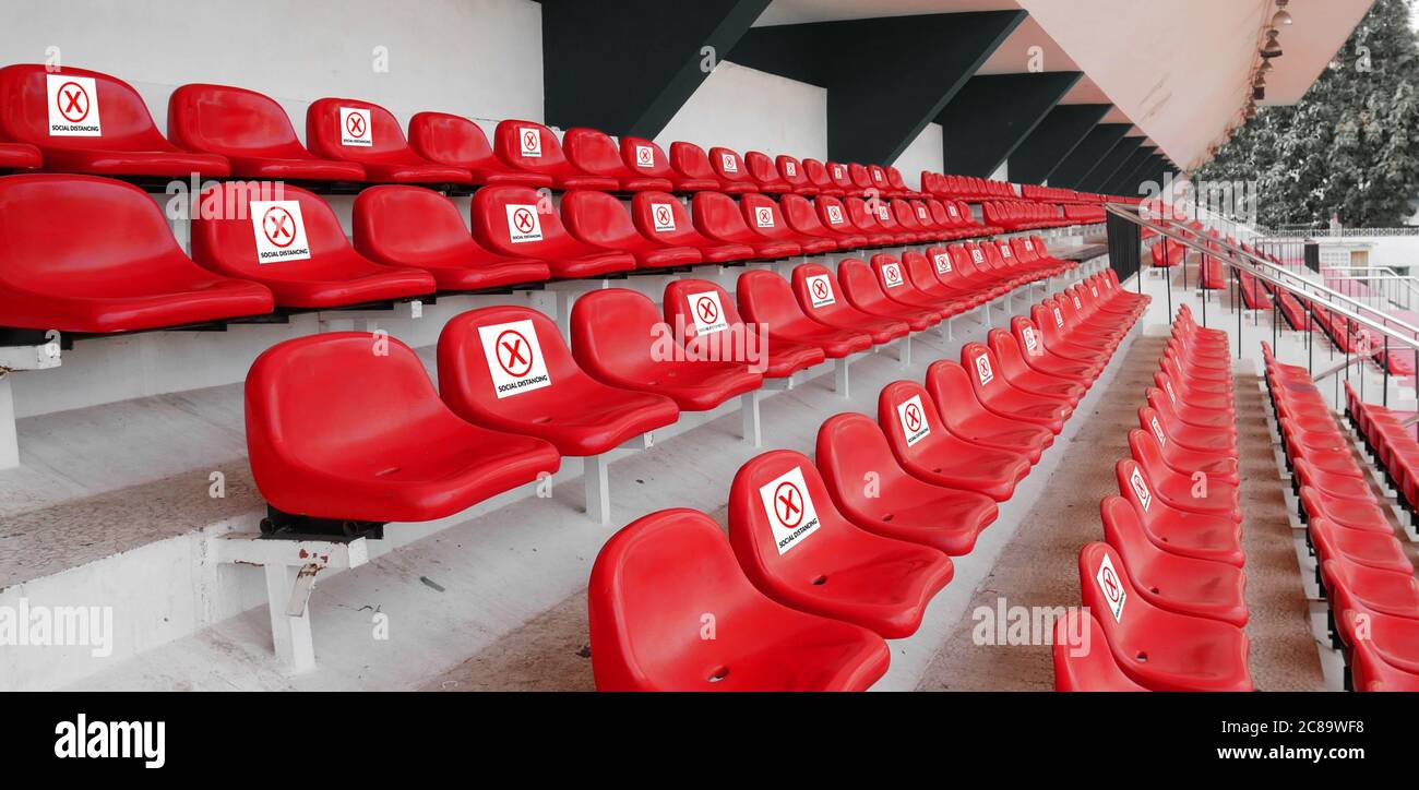 seat at sport audience, spectator with sign do not sit to for space on each chair at football sport stadium for physical distancing during coronavirus Stock Photo