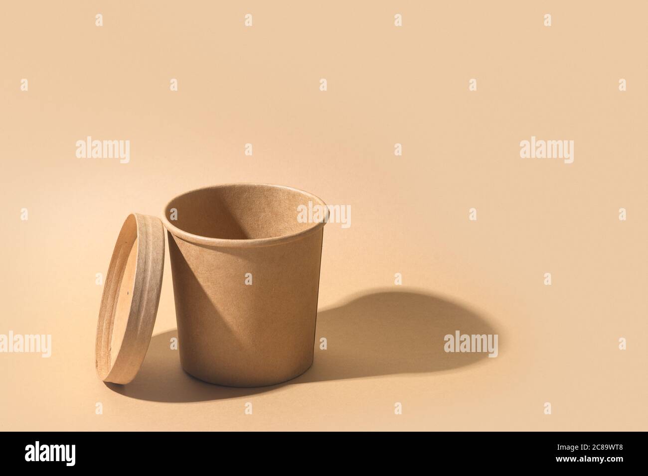 Craft paper soup cup with shadow on brown paper background. Empty ...