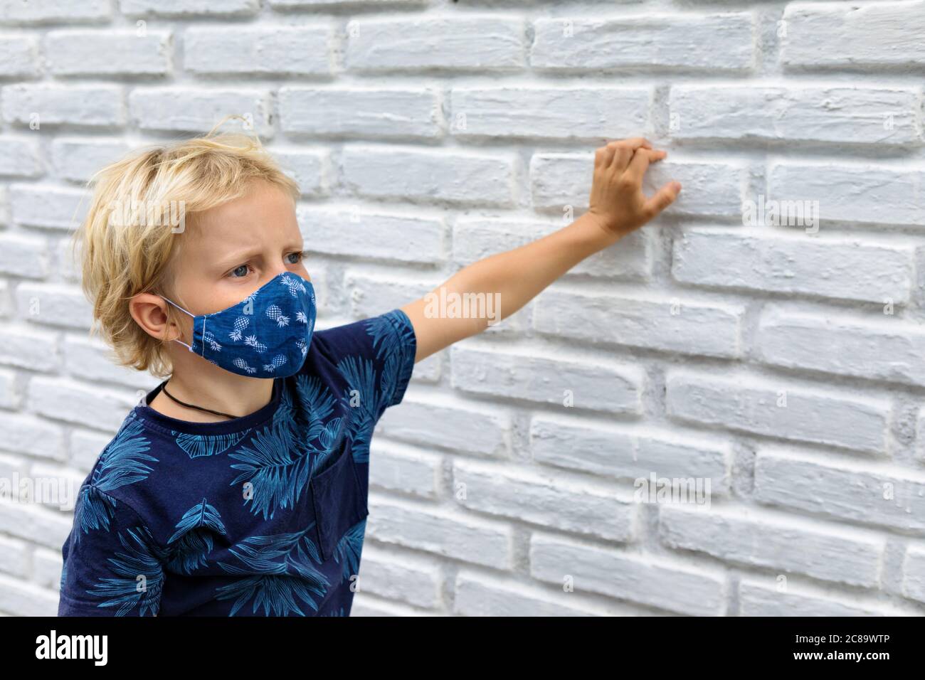 Portrait of child in funny protective mask. New rules to keep social distancing, wear face covering at public places. Cancelled cruise, tour due covid Stock Photo