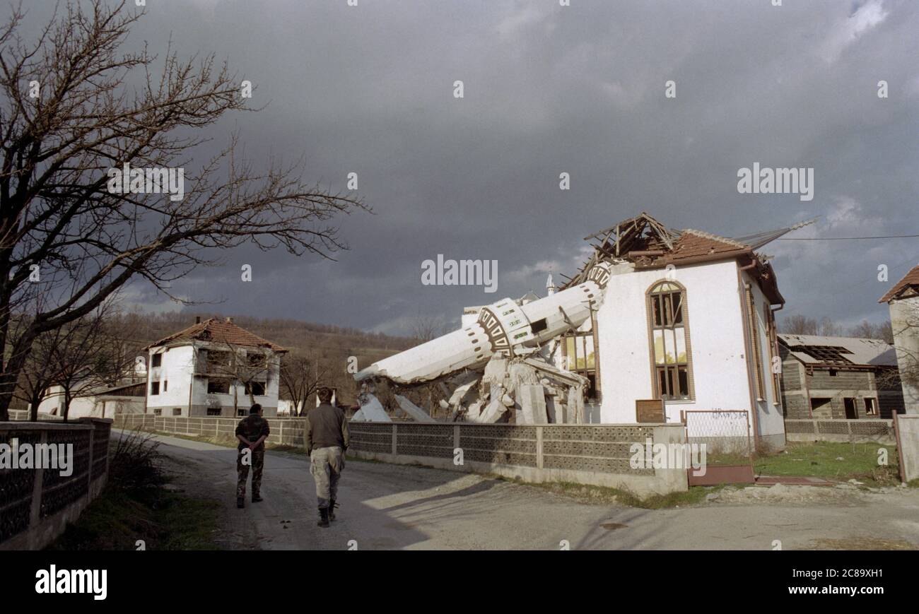 17th March 1994 During the war in Bosnia: Bosnian Croat (HVO) soldiers walk past the destroyed Donji Ahmići mosque in Ahmići, a few miles east of Vitez, in central Bosnia, where the HVO 'ethnically cleansed' the village on the 16th April 1993, murdering more than one hundred people. Stock Photo