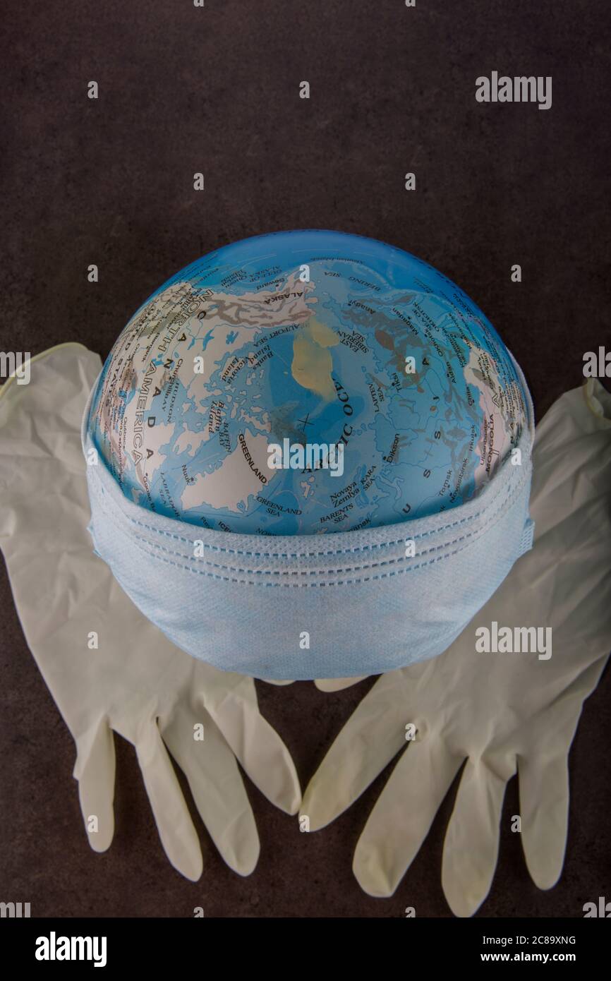 Earth globe with surgical mask and latex protection gloves. Stock Photo