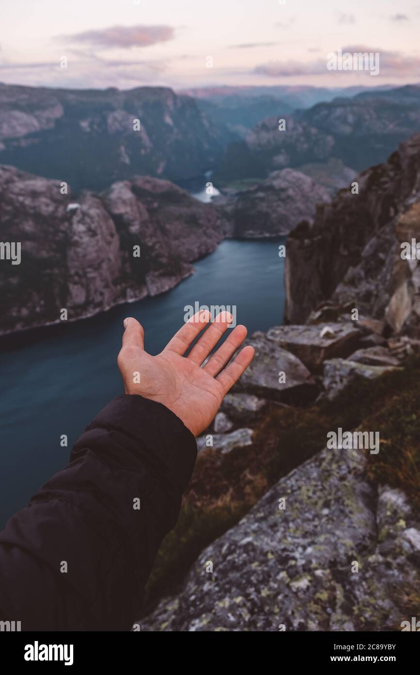 Open hand pointing to Norwegian fjords view at sunset Stock Photo - Alamy