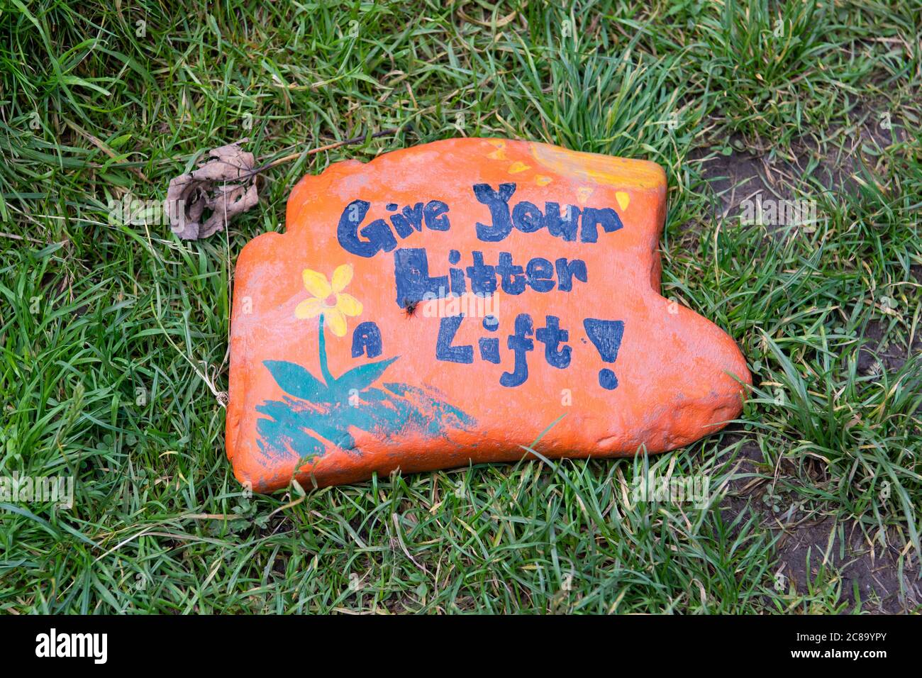 Give your litter a lift painted pebble rock - UK Stock Photo