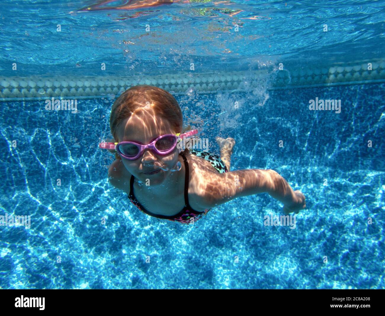 Girl swimming underwater with goggles on Stock Photo Alamy
