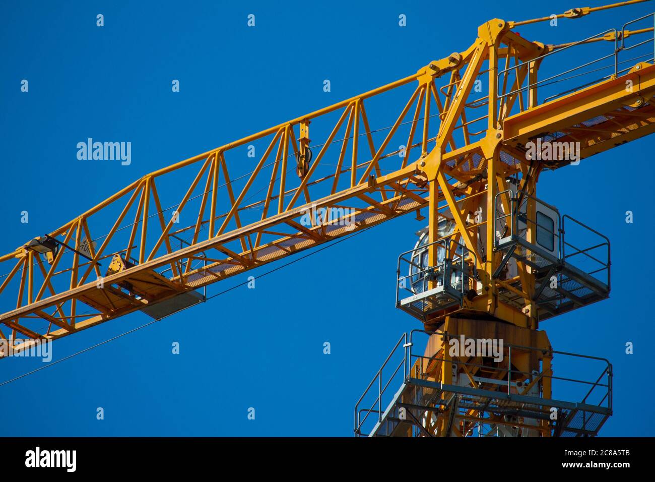 Yellow tower crane working on building against blue sky, selective focuse Stock Photo