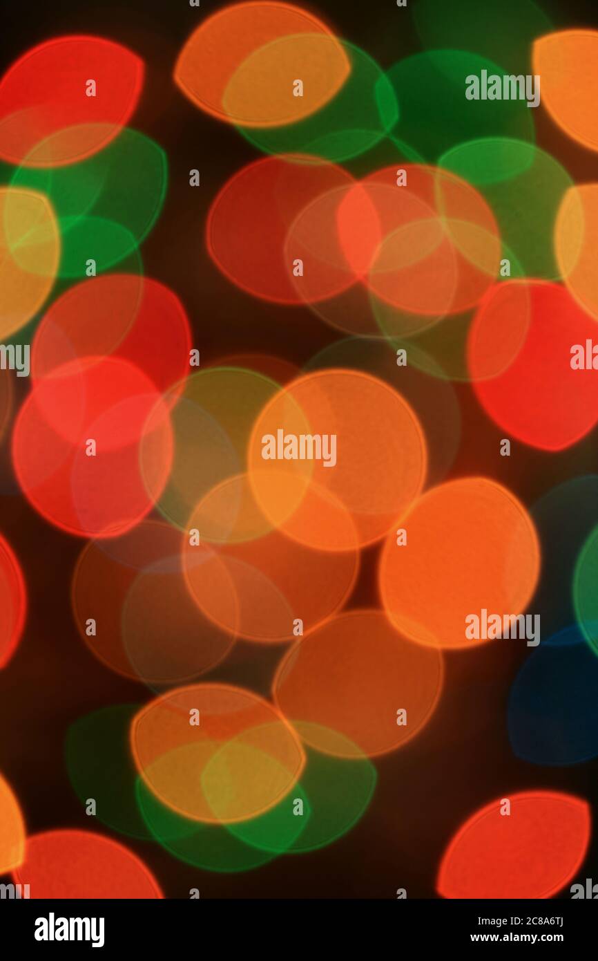 Vertical Image of Abstract Blurred Multi-color Glittering Illuminated Light on Black Background Stock Photo
