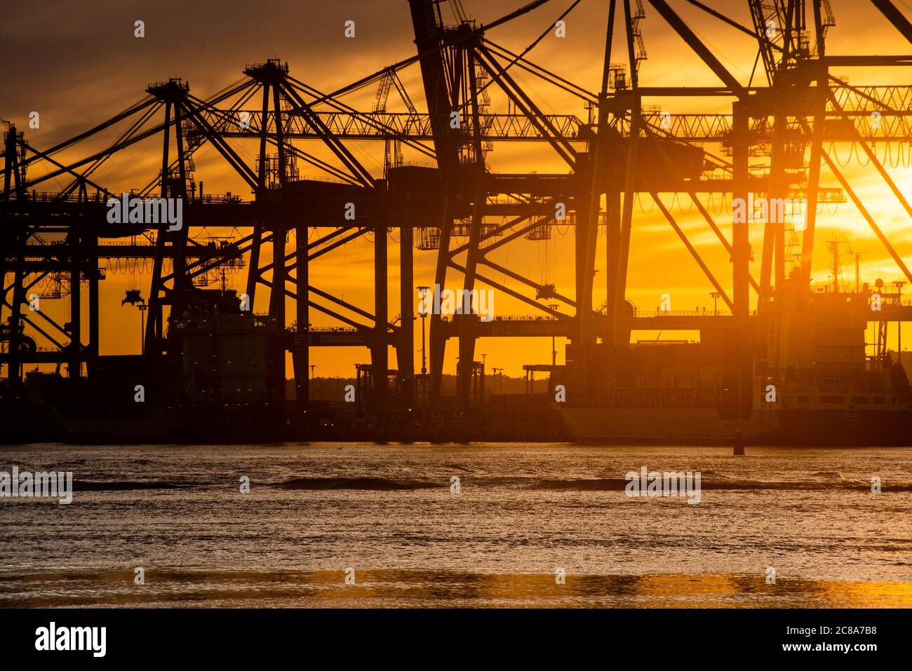 Silhouettes of ship to shore cranes at sunset.. Stock Photo