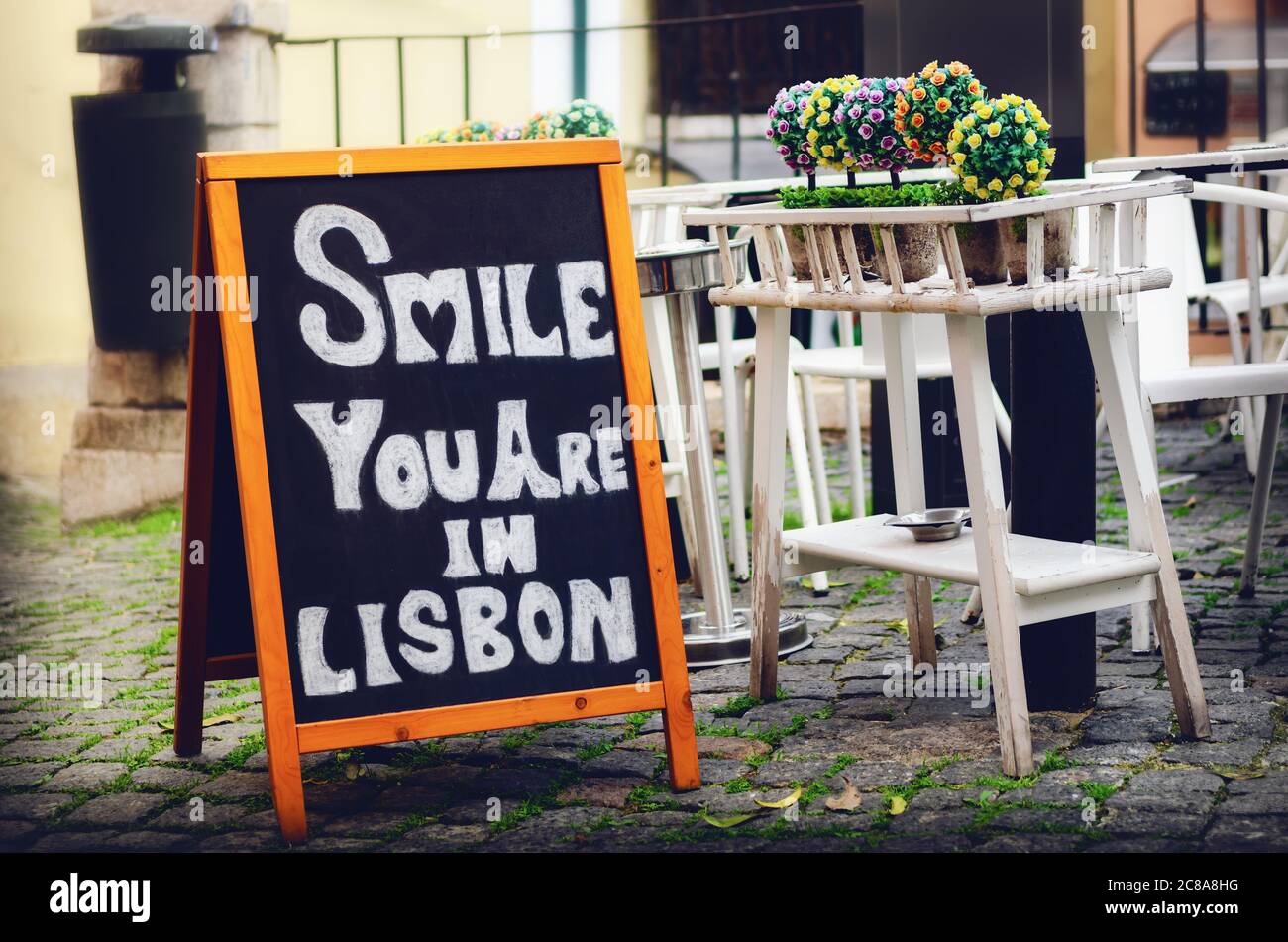 Blackboard with the message Smile you are in Lisbon in the streets of Alfama, historical touristic neighborhood of Lisbon, Portugal, famous for restau Stock Photo