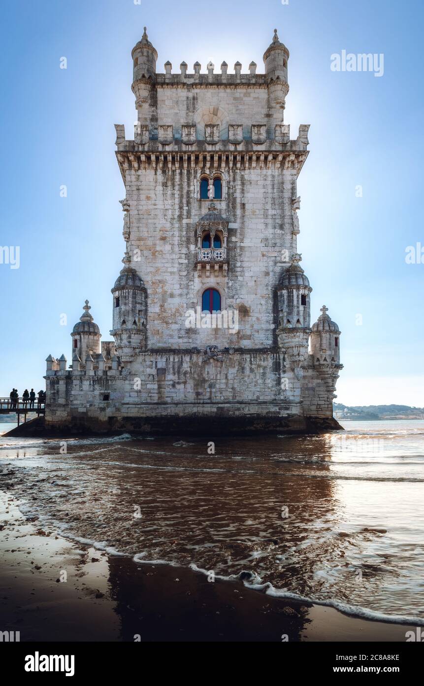 waves on the shore of the tagus river near the Tower of Belem, ancient bastion, fortress and symbol of Lisbon and of portuguese age of discoveries Stock Photo
