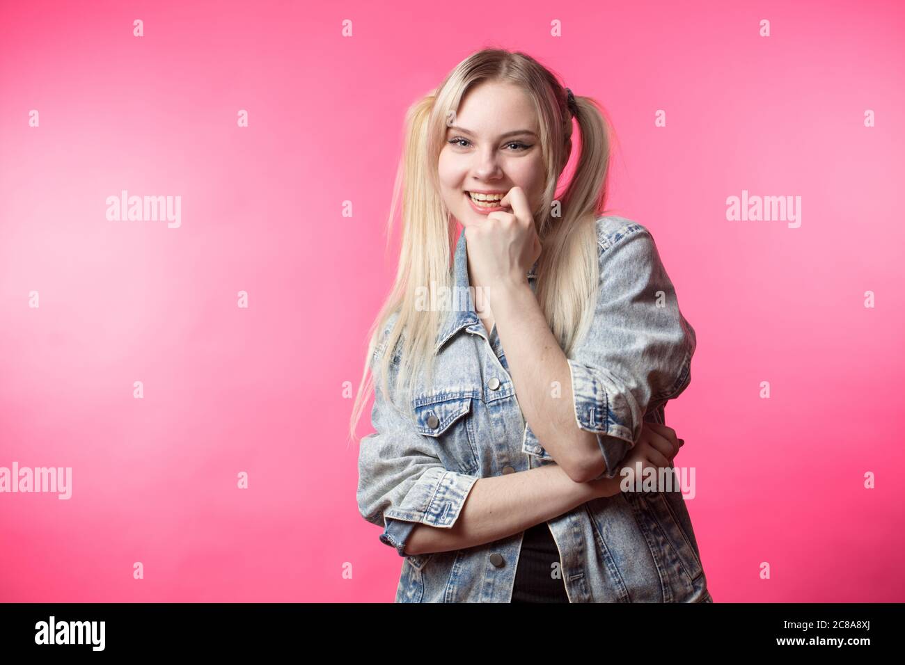 Pretty happy student girl with hair formed ponytails, having fun and flirting with us Stock Photo