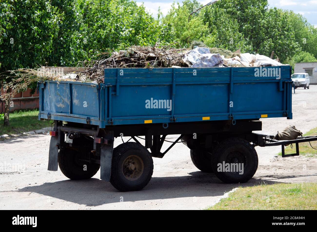 Cleaning dry branches and grass on city streets loading into truck