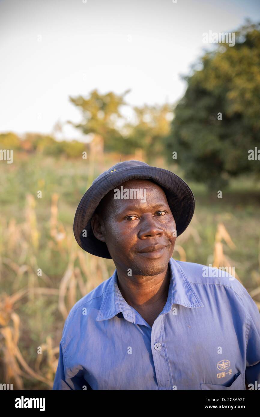 Portrait of a farmer standing in a corn field in a hat - Makueni County, Kenya, East Africa. Stock Photo