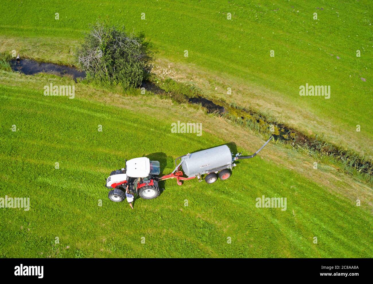 Fuessen, Germany, July 22, 2020.  Farmer sprinkles water on the field with his tractor  © Peter Schatz / Alamy Live News Stock Photo